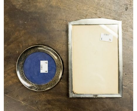 Two silver picture frames comprising an oblong arched engine turned 17 cm by 12 cm, Birmingham 1927 and a small round example