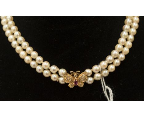 A two row cultured pearl necklace with a ruby and diamond 18ct gold butterfly clasp 