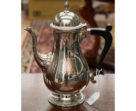 An Elizabeth II silver coffee pot in a mid 18th Century style with a pineapple finial on a domed lid, a fluted spout, gadroon