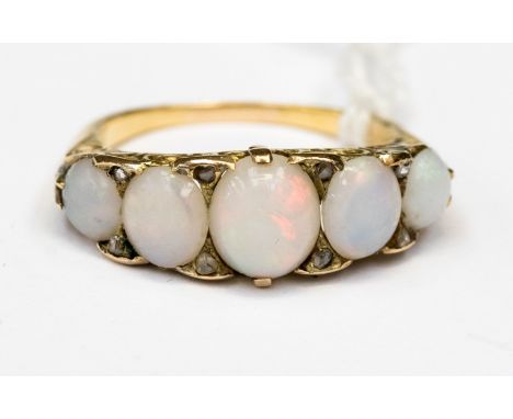 A Victorian five stone graduated opal ring in scroll mount, the oval cabochon opals displaying red, orange, purple fire,set i