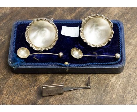 A pair of Edward VII silver circular salts with wavy raised rims, each on three pad feet, with spoons, Birmingham 1903, spoon