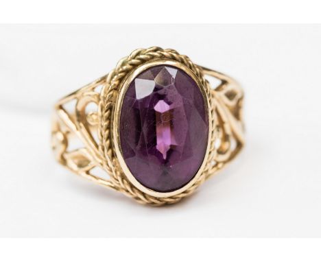 A 9ct. gold ring set faceted amethyst in pierced small shoulders