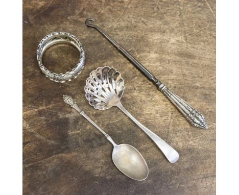 A collection of silver comprising napkin ring, sifter, a button hook and a white metal teaspoon, 42 grams/1.34 ozt approx (4)