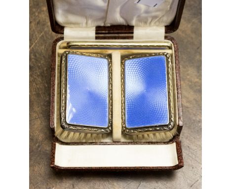 A cased silver and enamelled gentleman's hair set comprising pair of brushes and comb, the brushes having enamelled engine tu