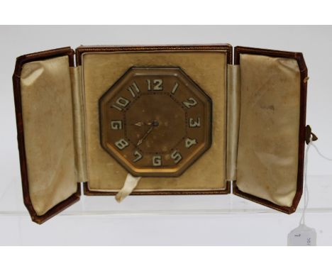 An early 20th century Harrods travelling clock, in a leather case