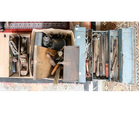 A metal tool box containing a collection of assorted tools, including pliers, screw drivers, spanners, files, hammers, chisel