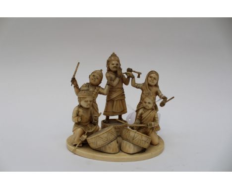  An Indian ivory carved group, depicting children playing instruments, circular base, signed to base 