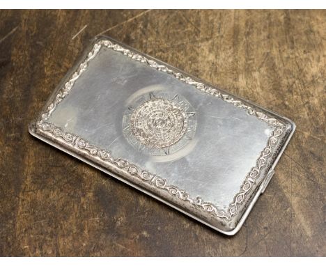 A Mexican silver cigarette case, rectangular form with applied cast yellow metal Mayan calendar motif within a foliate scrol