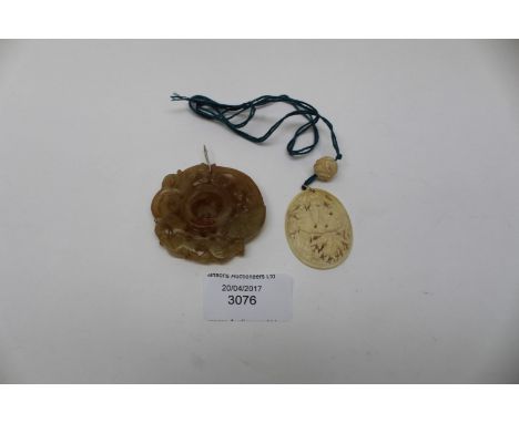 A late 19th/early 20th Century ivory carved pendant; together with a Jade carved pendant, with a central loose roundel, early
