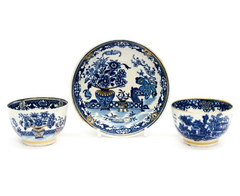 An early Worcester blue and white tea bowl and saucer, together with another tea bowl, all highlighted in gilt (3)