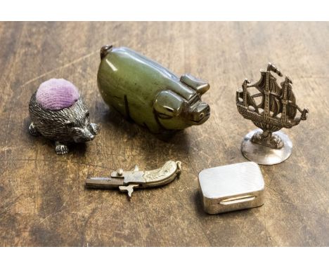 A silver pill box, white metal galleon, miniature gun, jade type Pig and Hedgehog pin cushion 