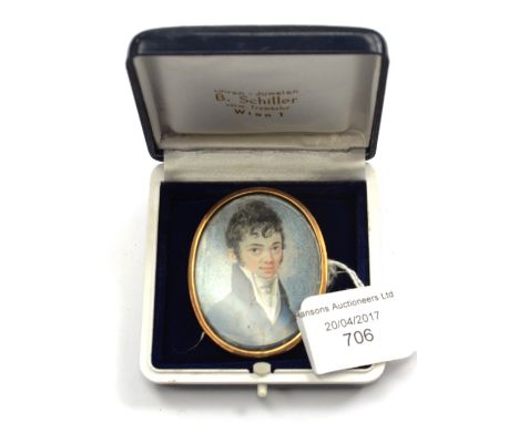 A 19th Century oval portrait miniature brooch depicting a young gentlemen, yellow metal surround, approx 55 by 42 mm 