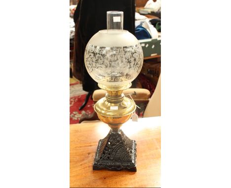 A late 19th century brass and cast iron oil lamp, complete with glass funnel and shade