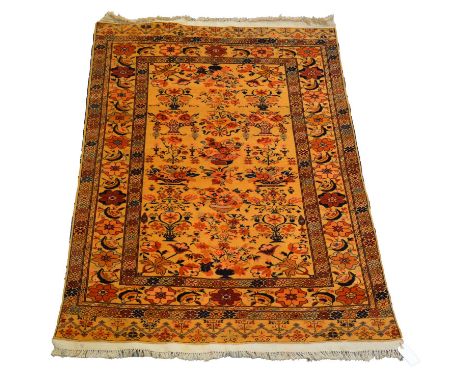 Four rugs including a Kashan rug with golden orange ground with floral vase motifs, 176cm x 125cm; a runner with small centra