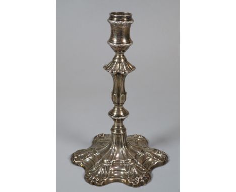 George III silver taper stick with fluted and gadroon banded stem on a scroll work petal base. London hallmarks for 1766, mak
