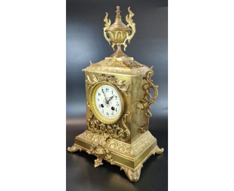 Early 20th century French repoussé brass mantle clock, having urn finial over ceramic Arabic face, overall with foliate decor