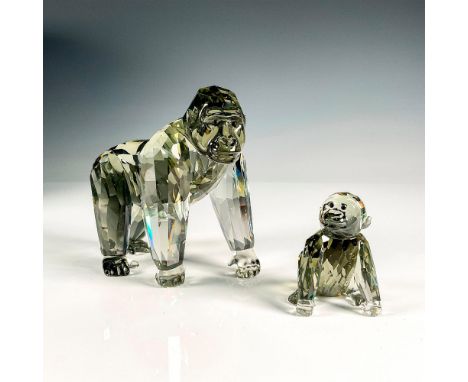 A pair of black crystal figures that depict a parent and baby gorilla with the parent gorilla standing on all fours and the b
