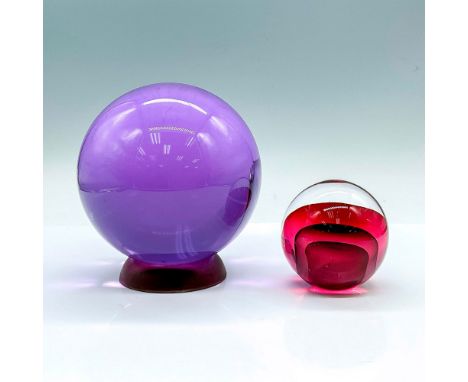 Paperweights in two different sizes. The larger piece is a light purple with a plastic base included. The small piece is clea