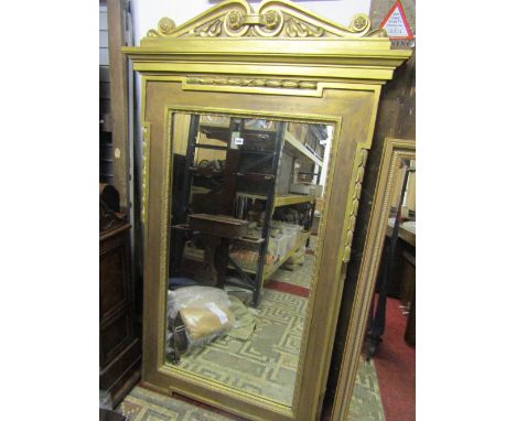 A reproduction gilt framed wall mirror, the ogee moulded rectangular frame with foliate detail beneath a scrolling architectu
