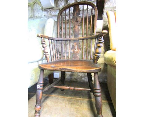 A 19th century Windsor hoop and stick back elbow chair in elm, ash and beechwood with central pierced splat over a saddle sha