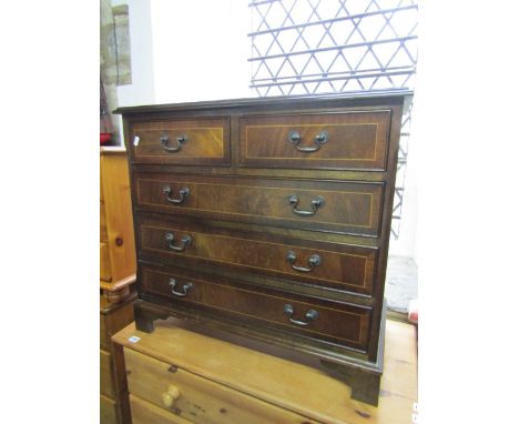A small reproduction mahogany veneered bedroom chest in the Georgian style, of three long and two short drawers, raised on br