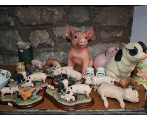 A quantity of ceramic and other ornaments relating to pigs including a large Italian model of a seated pig, various cast grou