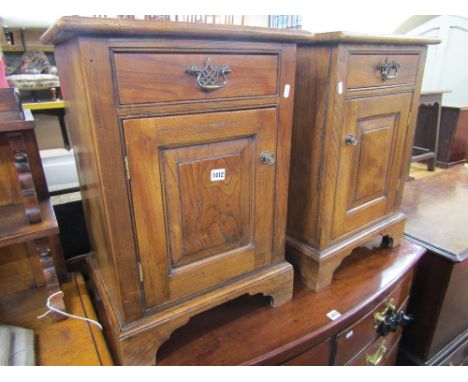 A pair of Georgian style elm side cupboards, each enclosed by a fielded panelled door and single frieze drawer, raised on bra