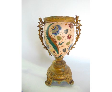 An unusual decorative painted ceramic vase with stylised painted floral decoration set within a gilt metal pedestal base with