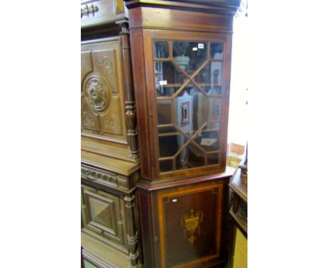 An Edwardian mahogany free standing two sectional corner cabinet with inlaid banding and urn detail, enclosed by two doors, t
