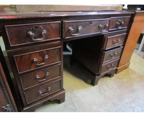 A small reproduction mahogany kneehole and twin pedestal desk of rectangular form with inset green leather writing surface ov