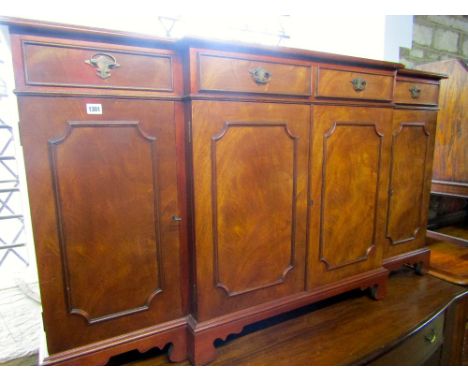 A reproduction mahogany shallow breakfront sideboard in the Georgian style fitted with four frieze drawers over cupboards rai
