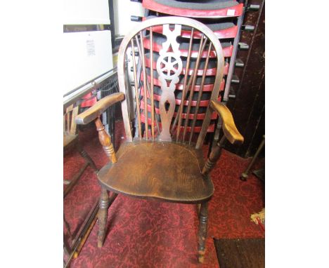 A Windsor elm and beechwood hoop and stick back open elbow chair with central pierced wheel splat over a saddle shaped seat r