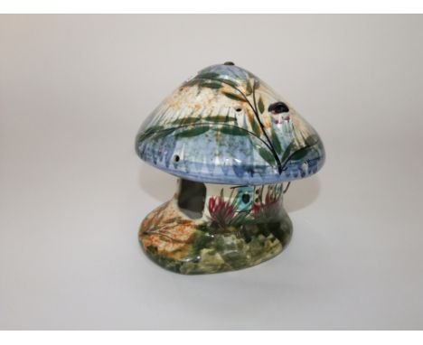 A Derek Fowler ceramic night light in the form of a mushroom shaped house with painted floral and leaf decoration inhabited b