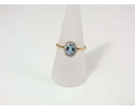 An 18ct gold aquamarine and diamond cluster ring, size R