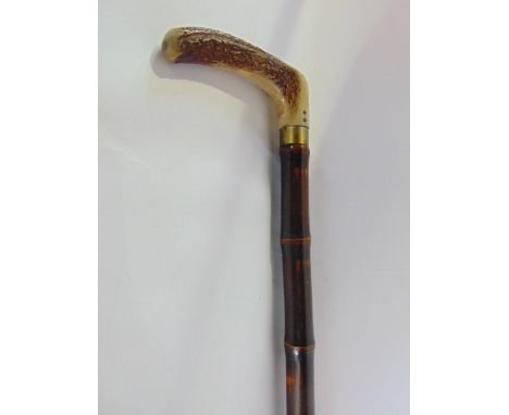 An early 20th century walking stick/horse measuring stick, the polished bamboo casing with a worked handle lifting to reveal 