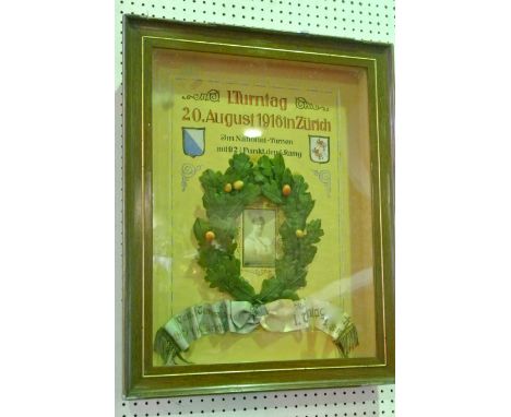 An early 20th century framed and glazed athletic dedication, a central photographic portrait card encircled by faux oak leave