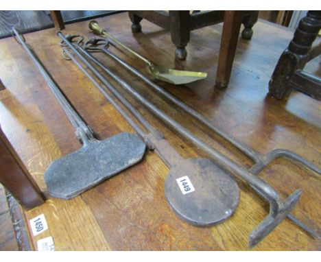 A collection of hand wrought country house fire irons including a fork, pusher, etc together with a brass shovel (5 pieces)