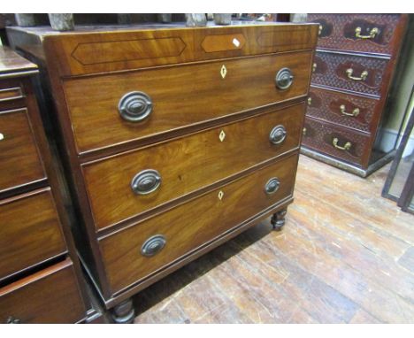 A small Georgian mahogany caddy top chest with cross banded detail over three long drawers and turned supports, with ebony an