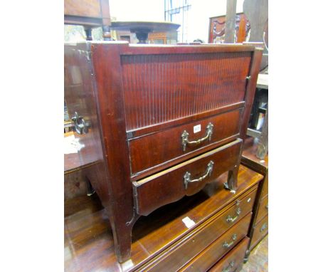 A 19th century continental mahogany bedside commode of rectangular form with raised gallery over a tambour front and two frie