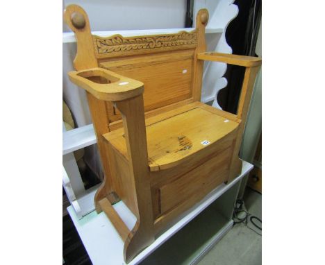 A stripped oak hall seat, the box base with hinged lid beneath a rectangular fielded panel flanked by stick stands and carved