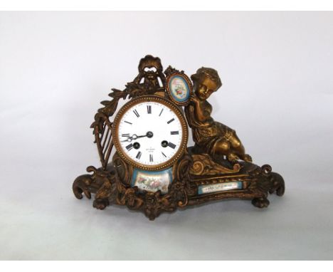 A 19th century gilded brass mantle clock with 8 day striking movement, the case with harp, floral swag, child and other detai