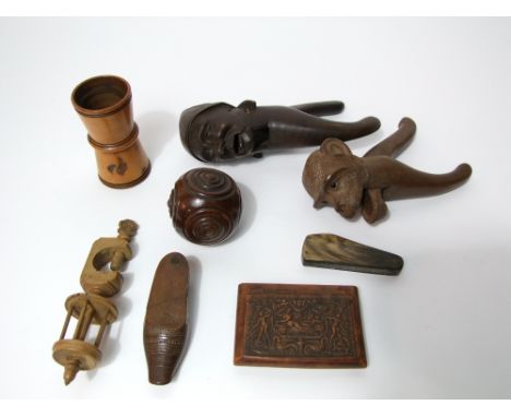 A pair of 19th century  carved timber nut crackers in the form of a monkeys head, another, a 19th century yew wood puzzle bal