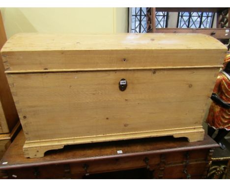 A 19th century continental stripped and waxed pine coffer, the domed lid over a tapering base raised on bracket supports, 125