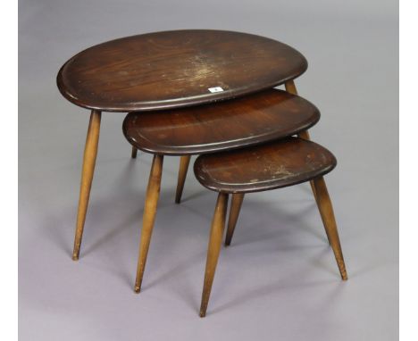 An Ercol dark elm nest of three oval occasional tables, each on three turned legs.