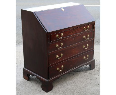 A Georgian mahogany bureau having a fitted interior enclosed by a fall-front above four long graduated drawers with brass swi