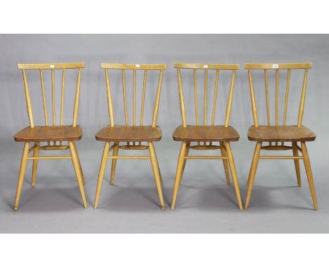 A set of four Ercol light elm spindle-back kitchen chairs each with a hard seat, &amp; on turned legs with spindle stretchers