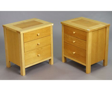 A pair of light oak three-drawer bedside chests, 53cm wide x 60.5cm high.