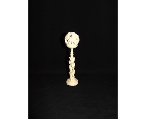 A CHINESE IVORY PUZZLE BALL ON STAND  late 19th or early 20th century, the dragon entwined outer ball with five concentric in