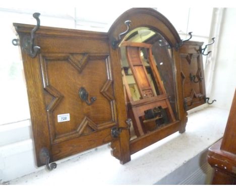 A good quality 1920s oak Jacobean style wall hanging mirror and coat rack, with central arched bevelled glazed mirror, flanke