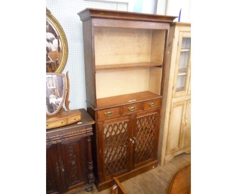 A 19th Century oak bookcase, the moulded cornice above open shelf, three frieze drawers and two lattice panelled cupboard doo